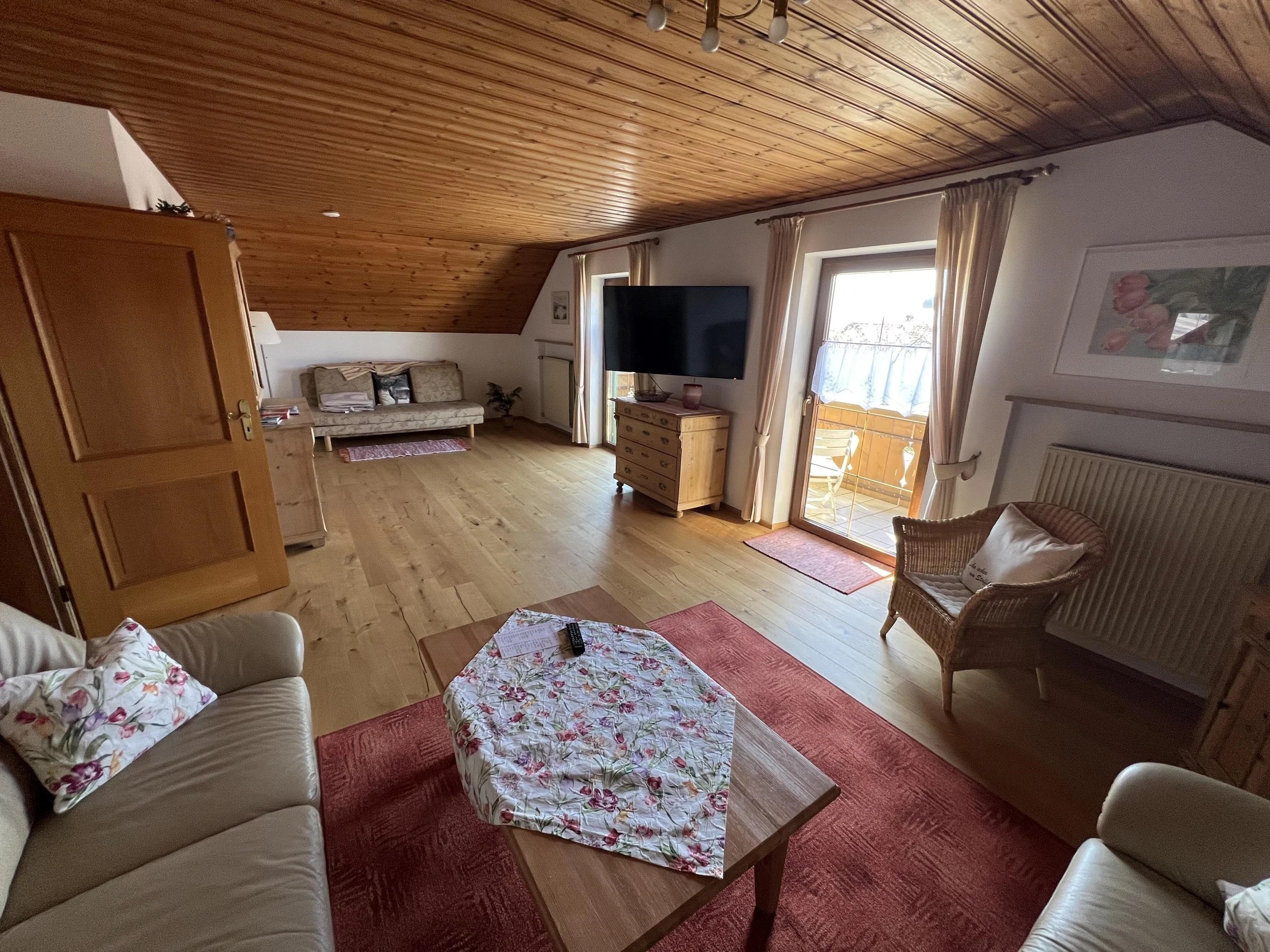 Heller Wohnbereich der Ferienwohnung Höbel mit Holzdecke, Sitzecke und bayerisch warmer Einrichtung